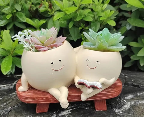 Pot people sitting together on the bench and reading Pot/Planter